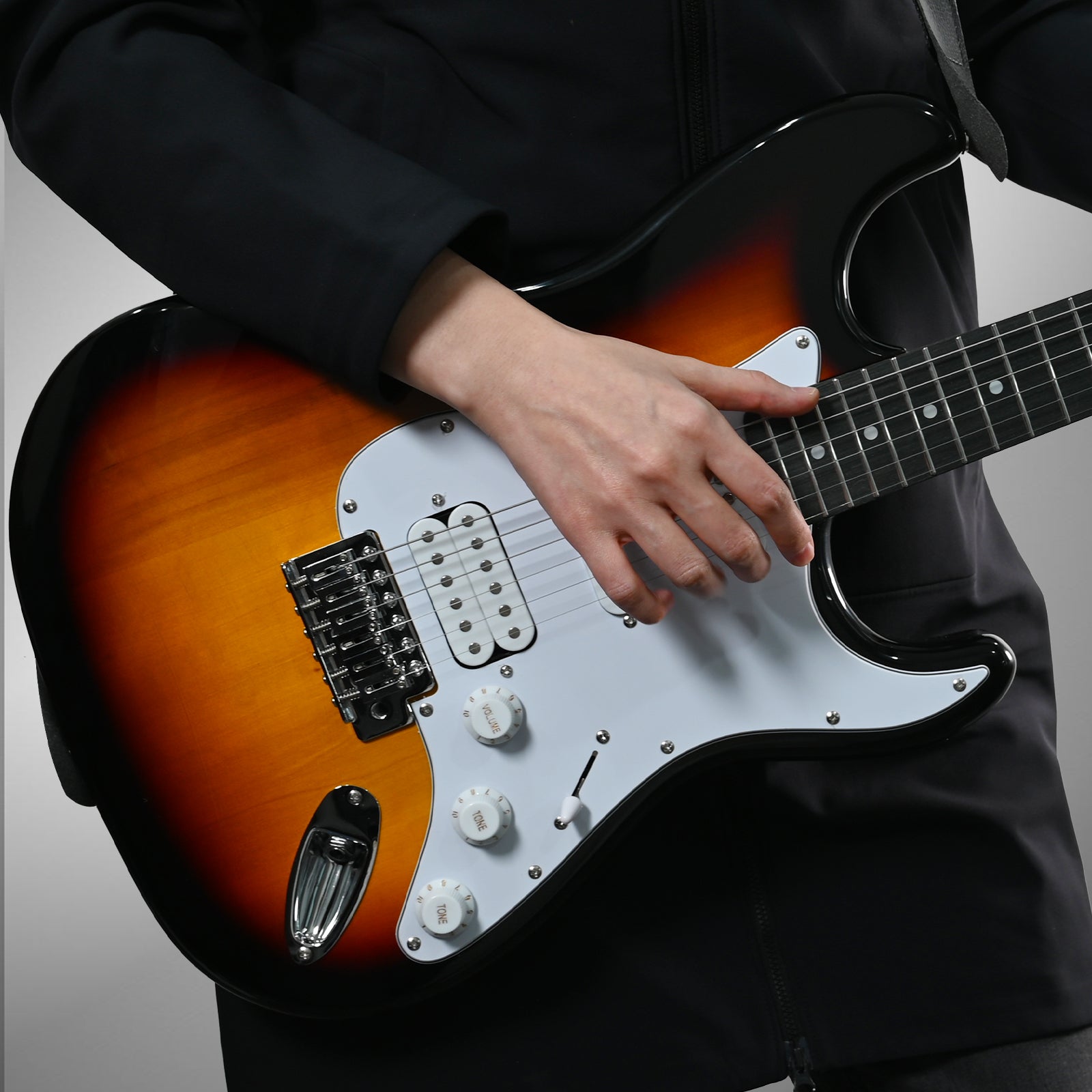 Musician playing GOLDRIFF 39-inch sunburst stratocaster-style electric guitar, showing HSS pickups and white pickguard